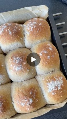 a pan filled with rolls covered in powdered sugar