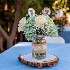 a mason jar filled with flowers sitting on top of a wooden slice covered in lace