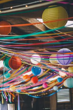 many colorful paper lanterns hanging from the ceiling