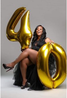 a woman sitting on top of a gold balloon