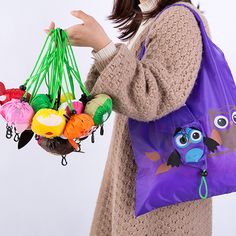 a woman holding a purple bag filled with lots of colorful items in her hands and wearing a brown sweater