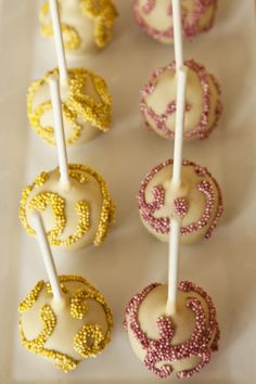 cake pops with white frosting and gold sprinkles