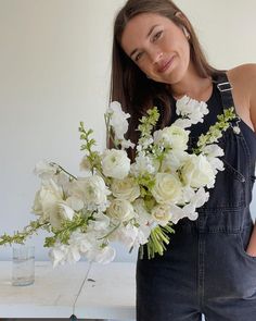 a woman holding a bouquet of white flowers