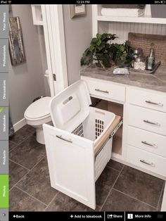 a bathroom with white cabinets and brown tile flooring