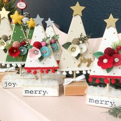 small wooden christmas trees are decorated with holiday decorations