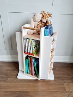 there is a book shelf with books and stuffed animals on it in the corner next to a door