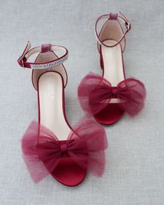 a pair of red high heeled shoes with a bow