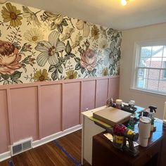 a room with pink paneling and flowers painted on the wall next to a window