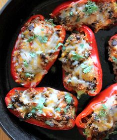 several stuffed peppers in a skillet with cheese and seasoning on top, ready to be eaten