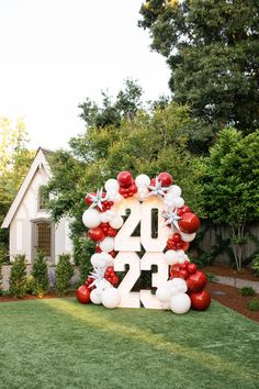 the number twenty four balloon arch is decorated with red, white and silver balloons