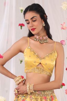 Mustard blouse in gajji satin base with floral embroidered motifs in cutdana and sequins.
Component: 1
Pattern: Embroidered
Type Of Work: Floral Motifs
Neckline: V-neck
Sleeve Type: Sleeveless
Fabric: Semi Crepe, Gajji Satin
Color: Yellow
Other Details: 
Cut-out details
Note: The lehenga worn by the model is not for sale
Occasion: Mehendi and Haldi - Aza Fashions Mustard Blouse, Sari Blouse, Blouse For Women, Indian Fashion Designers, Satin Color, Pernia Pop Up Shop, Sequins Embroidery, Blouse Online, V Neck Blouse