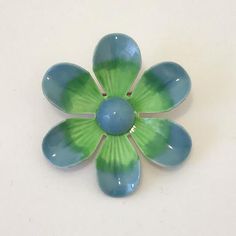 A 1960s mod enameled flower brooch. Fun and colorful, the brooch has blue and green flower petals radiating out from a Mediterranean blue center. Good vintage condition Measures 1.75”d Green Flower-shaped Enamel Brooch Pin, Green Flower Shaped Enamel Pin Brooch, Green Flower Enamel Pin Brooch, Mid-century Blue Brooches For Gifts, Green Flower-shaped Brooch Pins, Green Flower Shaped Brooch Pins, Green Flower Brooch Pins, 1960s Mod, Mediterranean Blue