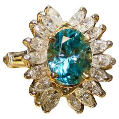 A beautiful and uniquely designed cocktail Ring done in platinum centered by an oval shape approximately 3.83ct natural zircon. The color is an absolutely gorgeous aqua with green undertones… very bright material. Flanking the center stones are marquise shaped diamonds and tapered baguettes on the shoulders. Total approximate diamond weight is 2.10cttw and all stones are G-I color and Vs1-2 clarity. Dimensions/Weight: Ring measures .75” by .65” and weighs 8.1g. Size 6.5 (sizable). Condition: All Luxury Blue Marquise Rings, Luxury Marquise Cut Multi-stone Rings, Fine Jewelry Sapphire Marquise Cut Multi-stone Ring, Luxury Blue Marquise Cut Jewelry, Luxury Sapphire Ring With Accent Stones, Marquise Cut, Marquise Shape Diamond, Marquise Diamond, Blue Zircon, Cocktail Ring