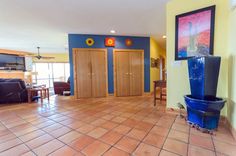 a living room filled with furniture and a large blue vase on top of a tiled floor