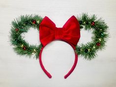 a minnie mouse ears headband is adorned with christmas greenery