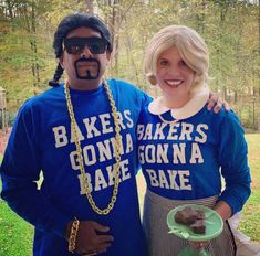 a man and woman in blue shirts standing next to each other with donuts on them