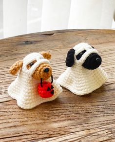 two crocheted dogs sitting on top of a wooden table