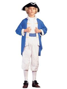 a little boy dressed in a colonial era outfit and hat, standing with his hands on his hips