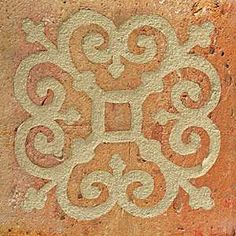 an ornate design is painted on the side of a brick wall with white swirls