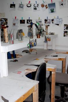 an office with several desks, chairs and pictures hanging on the wall above them