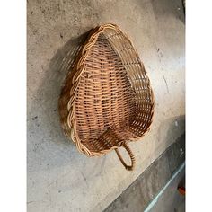 a wicker umbrella hanging on the wall next to a cement floor and concrete walls