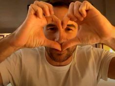 a man making a heart with his hands