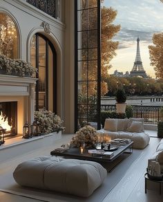 the living room is decorated in white and has a view of the eiffel tower