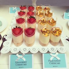 several desserts are arranged on a tray with utensils and place cards for each individual