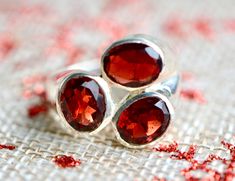 A stunning garnet ring in sterling silver featuring 3 large beautiful garnet gems. Garnet is the birthstone of January and a brilliant intense red. This ring makes a stunning statement. Size : Available in 8 (can be resized for a fee) Material : Sterling Silver Gemstones : 92.5 Sterling Silver, Garnet See other items from my store here https://www.etsy.com/shop/GalantaJewels?ref=hdr_shop_menu Authenticity : All sterling silver jewelry comes stamped with a 925 stamp which is a guarantee of authen Silver Three-stone Ruby Ring Gift, Silver Three Stone Ruby Ring As Gift, Silver Garnet Gemstones As Gift, Silver-toned Garnet Gemstones As Gifts, Statement Garnet Ring, Red Gemstone Ring, January Birthstone Rings, Sterling Silver Garnet Ring, Garnet Gem