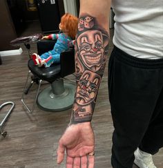 a man with a tattoo on his arm is standing in front of a barbershop