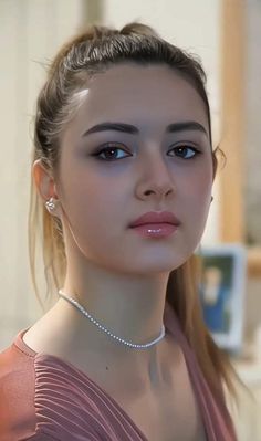 a young woman wearing a necklace and earrings