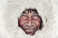 a man in a fur coat looking at the camera with an intense look on his face