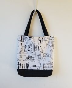 a black and white tote bag hanging on a wall