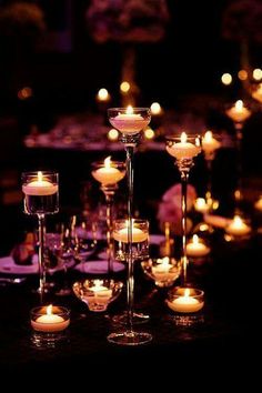 there are many candles that are lit up on the table in front of each other