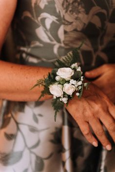 a close up of a person wearing a flower wrist corsage with flowers on it