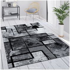 a large rug with black and white squares on it in a living room next to a chair