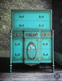 an old dresser painted in turquoise with gold trim