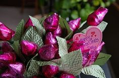 a vase filled with pink roses and green leaves