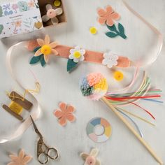 crafting supplies laid out on a table including scissors, flowers and other things to make it