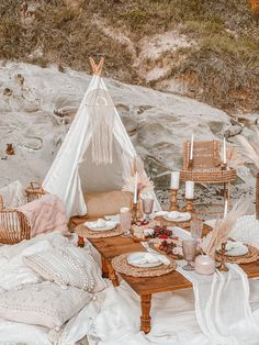 a table set up for a picnic with a teepee tent in the background