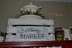 a wooden sign that says farmer's market sitting on top of a red shelf