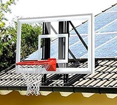 a basketball hoop is hanging off the side of a building with solar panels on it