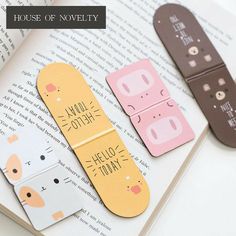 three bookmarks that say house of novelty and hello town on top of an open book