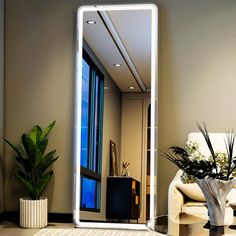 a large mirror sitting on top of a table next to a plant