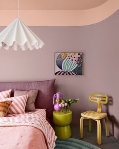 a bed room with a neatly made bed and a painting on the wall above it