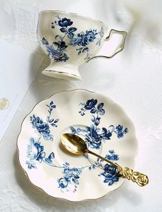 two blue and white teacups with gold spoons