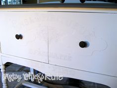 a white painted dresser with black handles and knobs