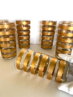 gold striped glasses and napkins on a white table