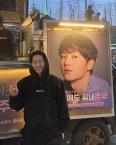 a man standing in front of a food truck giving the peace sign with his hand