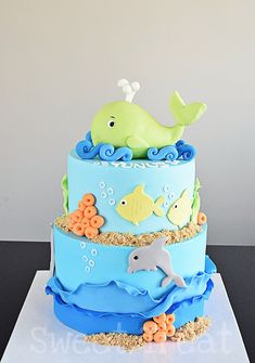 a three tiered cake decorated with an ocean theme